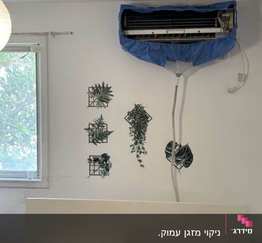 מזגן עם כיסוי כחול על קיר בחדר שינה